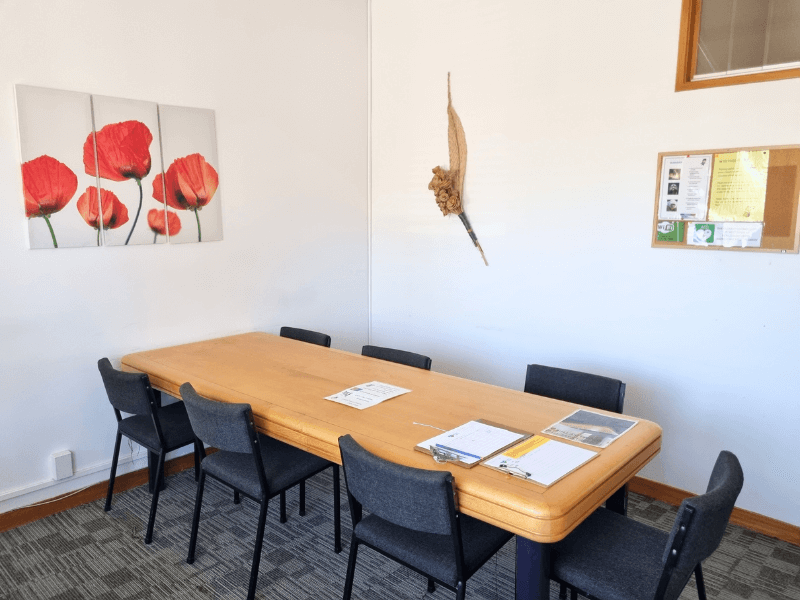 View of Meeting Room 4 when standing at the window, can see poppy flowers and other wall art as well as a notice board